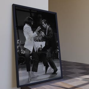 Könnte beinhalten: Schwarz-Weiß-Druck in einem Rahmen, der eine Filmszene zeigt. Das Bild zeigt einen Mann und eine Frau beim Tanzen. Die Frau trägt ein weißes Hemd und eine schwarze Hose. Der Mann trägt einen schwarzen Anzug. Der Rahmen ist schwarz.