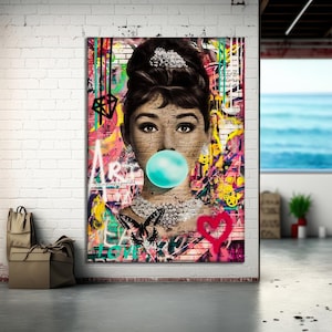 Può includere: Opera d'arte da parete in stile pop art con un ritratto di donna con una bolla di gomma da masticare. L'opera incorpora elementi graffiti, una farfalla e un cuore. Lo sfondo è un mix di colori vivaci, tra cui rosa, giallo e verde.