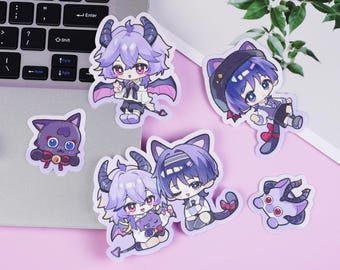 Könnte beinhalten: Eine Sammlung von Aufklebern im Anime-Stil mit verschiedenen Charakteren mit lila und blauen Haaren, Hörnern und Katzenohren. Die Aufkleber befinden sich auf einer rosa Oberfläche mit einem Laptop und dekorativen Eiswürfeln im Hintergrund.