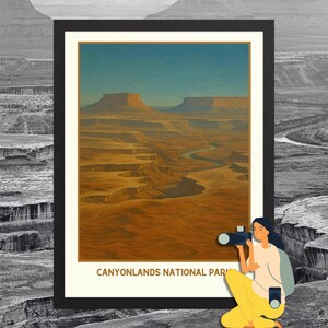 May include: Framed art print featuring a landscape of Canyonlands National Park. The artwork depicts a canyon with a river winding through it, under a blue sky. The text "CANYONLANDS NATIONAL PARK" is at the bottom. A person is holding a camera.