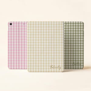 May include: Three tablet cases in pink, beige, and green, each with a gingham pattern. The beige case has the name "Felicity" in gold script, and the green case has the name "Caitlin".
