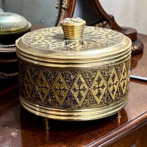 May include: A set of three ceramic mugs with a speckled, cream-colored glaze. Each mug features a different hand-painted floral design in shades of blue, green, and yellow. The mugs have a simple, modern shape.