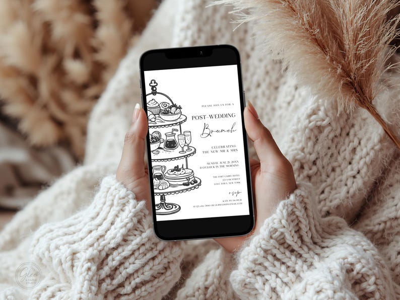 May include: A smartphone displays a black and white invitation for a post-wedding brunch. The invitation features a tiered serving tray with food and drinks, and the text "Post-Wedding Brunch" in elegant script.