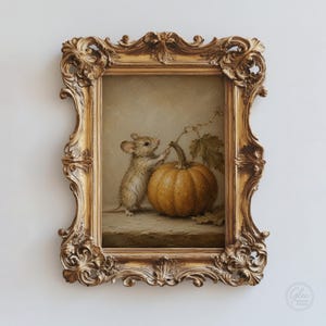 Peut inclure: Une peinture encadr&eacute;e repr&eacute;sentant une petite souris brune debout &agrave; c&ocirc;t&eacute; d'une citrouille orange ronde avec une vigne et une feuille. L'&oelig;uvre est ins&eacute;r&eacute;e dans un cadre dor&eacute; orn&eacute;, dot&eacute; de volutes complexes et de d&eacute;tails sculpt&eacute;s.