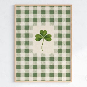 Puede incluir: Impresi&oacute;n enmarcada con un tr&eacute;bol verde sobre un fondo crema, sobre un patr&oacute;n de cuadros verdes y blancos. La obra de arte est&aacute; en un marco de madera marr&oacute;n claro. Ideal para la decoraci&oacute;n del D&iacute;a de San Patricio.
