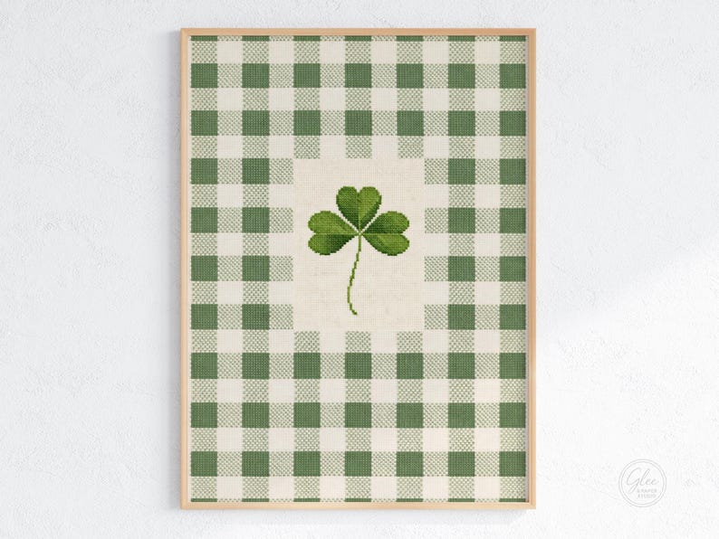 Puede incluir: Impresi&oacute;n enmarcada con un tr&eacute;bol verde sobre un fondo crema, sobre un patr&oacute;n de cuadros verdes y blancos. La obra de arte est&aacute; en un marco de madera marr&oacute;n claro. Ideal para la decoraci&oacute;n del D&iacute;a de San Patricio.