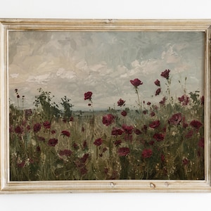 Puede incluir: Un cuadro de paisaje enmarcado que muestra un campo de amapolas de color rojo intenso bajo un cielo nublado y apagado. La obra utiliza pinceladas visibles y texturizadas para representar las flores y hierbas, dentro de un marco de madera clara.