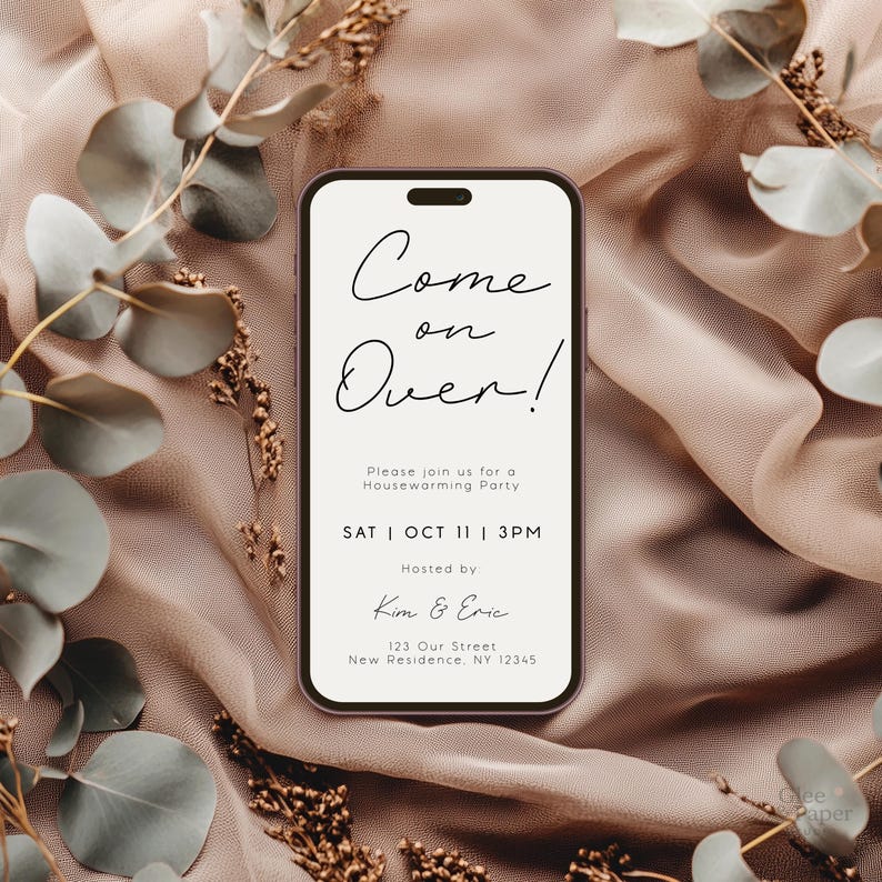 May include: A smartphone-shaped invitation with the words "Come on Over!" in elegant script. The invitation is for a housewarming party on October 11th at 3 PM, hosted by Kim & Eric. The design is set against a soft, neutral background with floral accents.