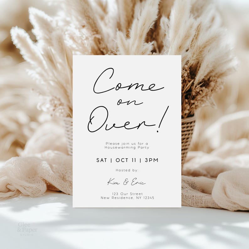 May include: A cream-colored invitation with the words "Come on Over!" in elegant script. The invitation includes details for a housewarming party, with the date, time, and hosts' names. The background features dried floral arrangements.