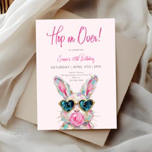 Puede incluir: Una invitación de cumpleaños rosa con el texto "Hop on Over!" y "Emma's 10th Birthday." Presenta una ilustración de acuarela de un conejito con gafas de sol en forma de corazón y soplando una burbuja. La invitación incluye detalles del evento.