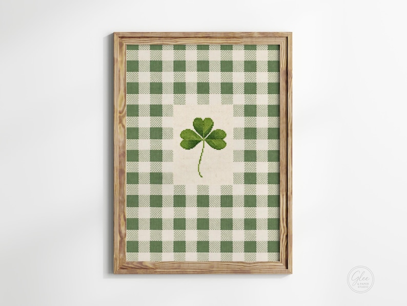 Puede incluir: Impresi&oacute;n enmarcada con un patr&oacute;n de cuadros verdes y blancos y un tr&eacute;bol central. La obra de arte est&aacute; en un marco de madera, ideal para el D&iacute;a de San Patricio. El dise&ntilde;o tiene una est&eacute;tica r&uacute;stica y encantadora, adecuada para la decoraci&oacute;n del hogar.