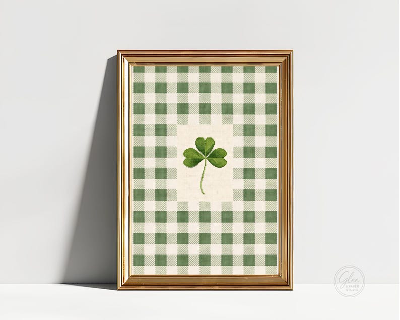 Puede incluir: Una impresi&oacute;n enmarcada con un tr&eacute;bol verde sobre un fondo crema, sobre un patr&oacute;n de cuadros verdes y blancos. La impresi&oacute;n est&aacute; en un marco dorado, creando una pieza cl&aacute;sica y decorativa.