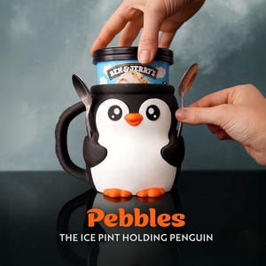 Könnte beinhalten: Ein schwarz-weiß-oranger Pinguin-Eisbecherhalter mit Griff. Der Pinguin hat große weiße Augen und einen orangefarbenen Schnabel und Füße. Der Text "Pebbles THE ICE PINT HOLDING PENGUIN" ist darunter.