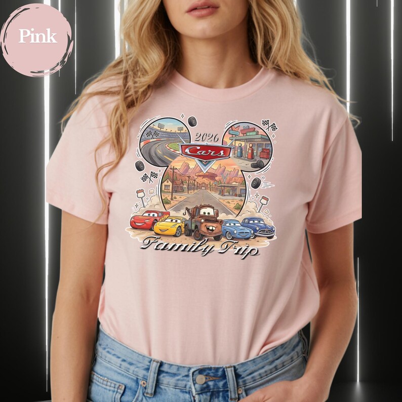 Puede incluir: Camiseta rosa claro con un dise&ntilde;o gr&aacute;fico de la pel&iacute;cula Cars. El dise&ntilde;o incluye el texto "2026 Cars Family Trip" e im&aacute;genes de circuitos y una ciudad des&eacute;rtica. La camiseta est&aacute; hecha de un material suave.