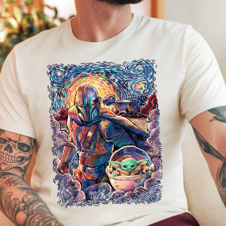 May include: Off-white t-shirt with a colourful illustration of The Mandalorian and Grogu, set against a swirling, starry night sky. The artwork showcases the characters in a vibrant, artistic style, with a spaceship in the background. A unique graphic tee.