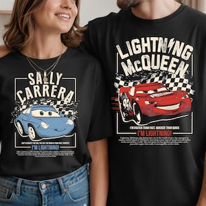 May include: Black t-shirts featuring characters from the movie Cars. One shirt displays a blue car with "SALLY CARRERA" text. The other shirt shows a red car with "LIGHTNING McQUEEN" text and the phrase "I'M LIGHTNING!"