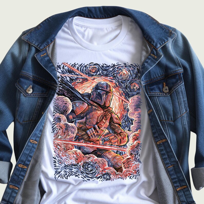 May include: White t-shirt featuring a detailed illustration of a character in armor, set against a swirling, colorful background reminiscent of a starry night. The shirt is layered under a blue denim jacket, creating a casual, layered look.