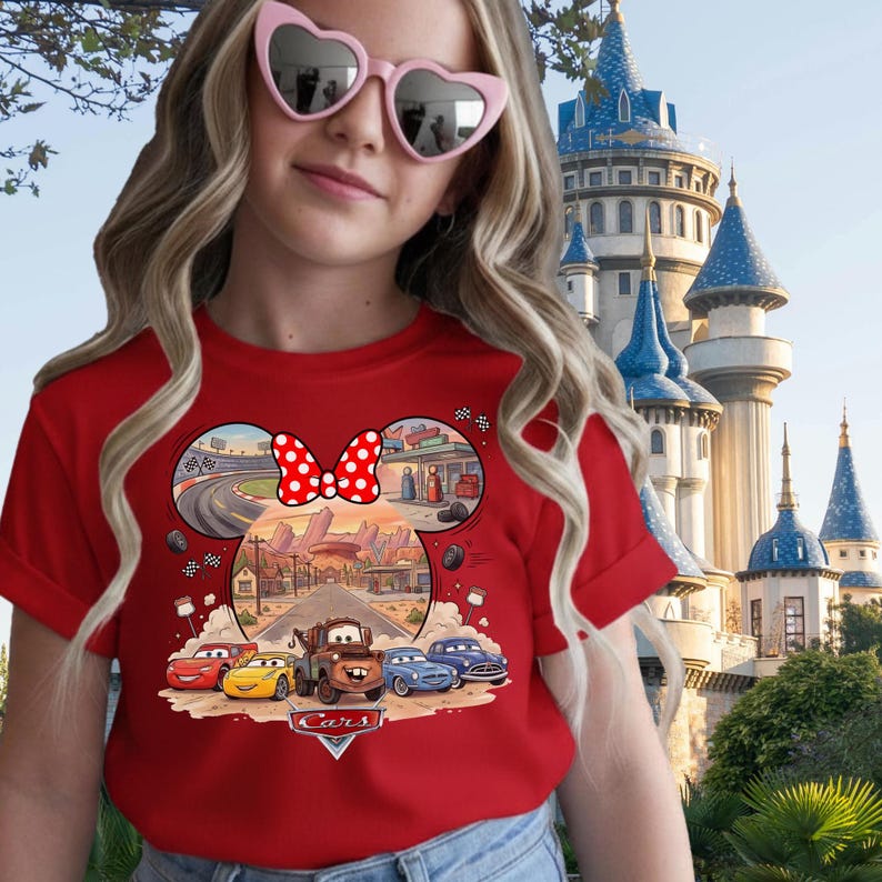 Pode incluir: Uma t-shirt vermelha com um gr&aacute;fico das personagens do filme Disney Pixar Carros, incluindo Rel&acirc;mpago McQueen e Mate. O design est&aacute; inserido numa silhueta de orelhas do Rato Mickey, com um la&ccedil;o vermelho de bolinhas brancas e o log&oacute;tipo Cars.