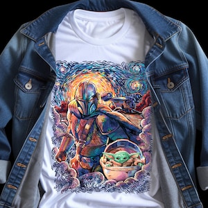 May include: White t-shirt with a colourful illustration of The Mandalorian and Grogu, set against a starry night sky. The artwork is reminiscent of Van Gogh's style, with swirling brushstrokes and vibrant colours. The shirt is paired with a denim jacket.