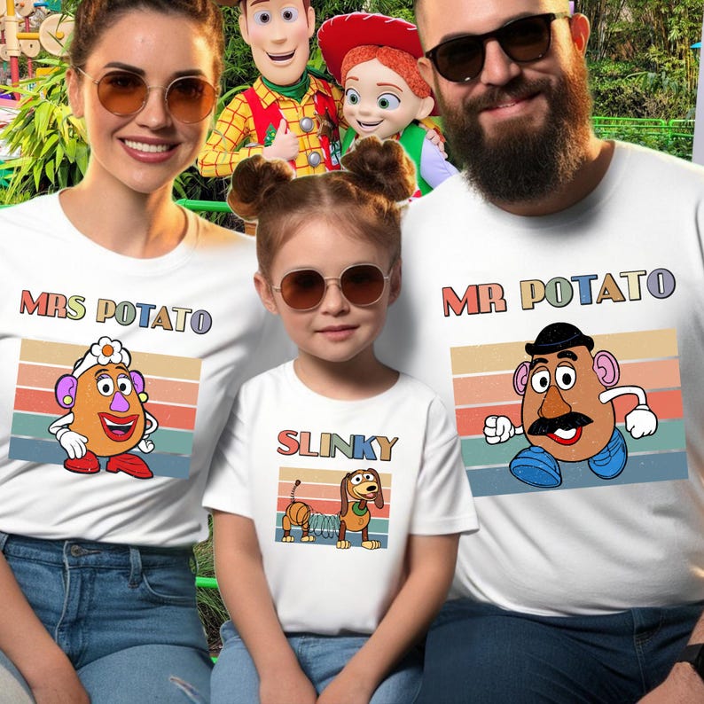 May include: Three white t-shirts featuring retro-style graphic prints of characters. One shirt displays Mrs. Potato with the text "MRS POTATO", one shows Slinky with the text "SLINKY", and one features Mr. Potato with the text "MR POTATO".