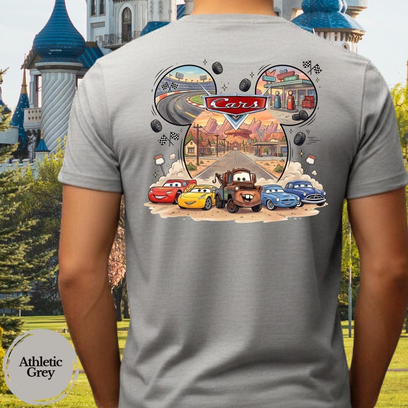 Pu&ograve; includere: Una t-shirt grigio chiaro con una stampa grafica dei personaggi Disney Pixar Cars, tra cui Saetta McQueen e Cricchetto. Il design include una strada, un circuito, una stazione di servizio e il logo Cars, disposti a forma di testa di Topolino.
