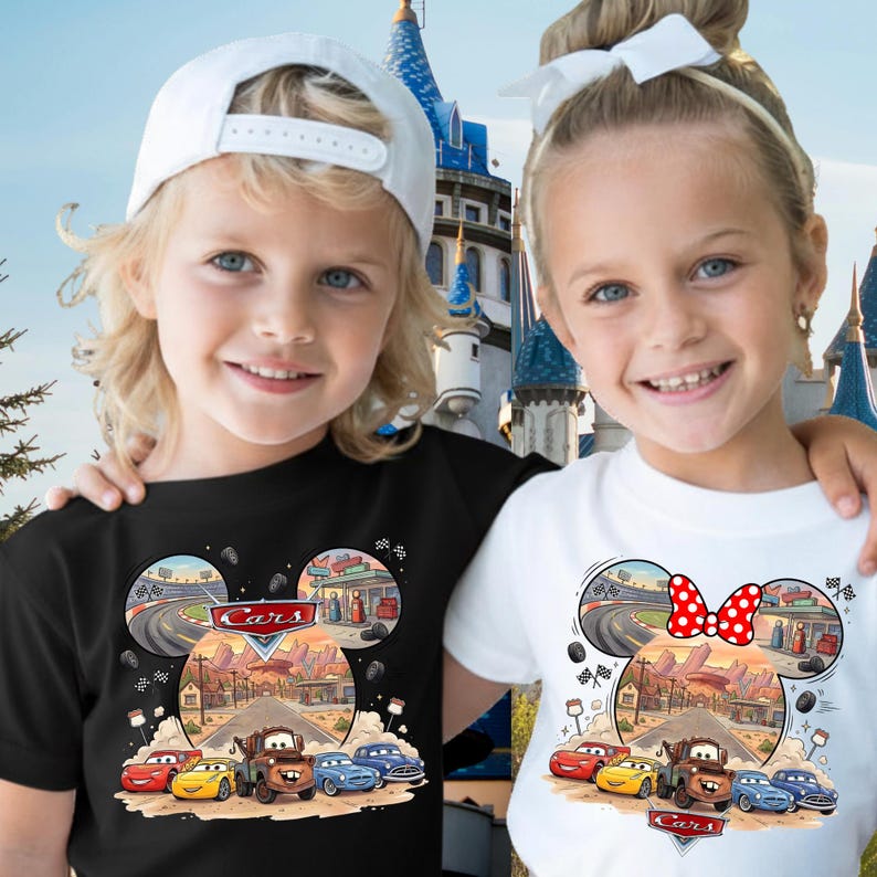 Pode incluir: Uma t-shirt preta e uma t-shirt branca, cada uma com uma impress&atilde;o gr&aacute;fica das personagens e cen&aacute;rios do filme Cars dispostos em forma de orelhas do Mickey Mouse. O design inclui uma pista de corrida, paisagem des&eacute;rtica e v&aacute;rios carros.