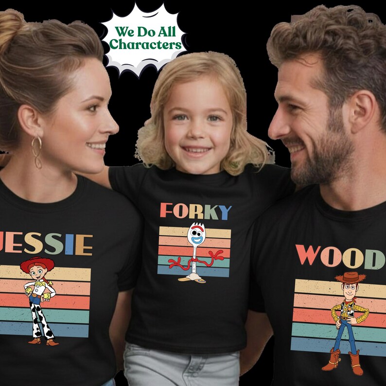 May include: Three black t-shirts featuring Toy Story character graphics. The left shirt shows Jessie with the text "JESSIE", the center shirt shows Forky with the text "FORKY", and the right shirt shows Woody with the text "WOOD". Each design includes a retro-style horizontal striped background.