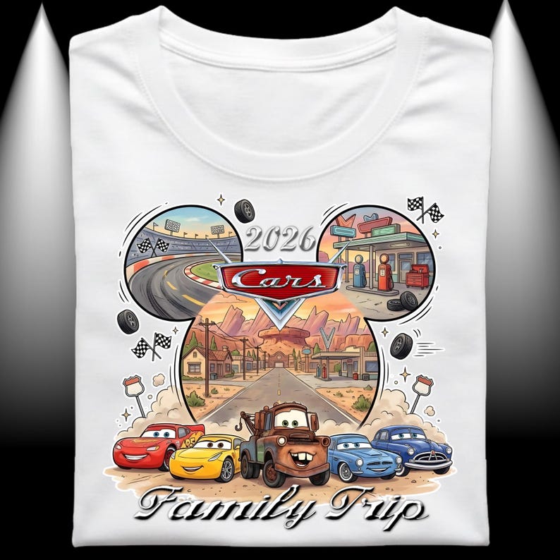 Puede incluir: Camiseta blanca con un gr&aacute;fico colorido de los personajes de Cars. El dise&ntilde;o incluye una pista de carreras, una gasolinera y el texto "2026 Cars Family Trip". El gr&aacute;fico muestra a Rayo McQueen, Mate y otros personajes.