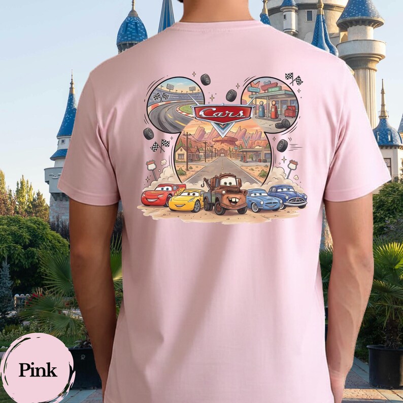 Pu&ograve; includere: Una t-shirt rosa chiaro con una grafica sul retro che mostra il logo Disney Cars e personaggi come Saetta McQueen, Cricchetto e altri veicoli. Il design &egrave; incorniciato a forma di orecchie di Topolino e mostra una scena di strada nel deserto.
