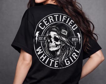 May include: A black t-shirt featuring a large circular graphic on the back. The design includes a skull wearing a baseball cap, surrounded by the text "CERTIFIED WHITE GIRL" and "EST. AT. BIRTH" with lightning bolt accents in white ink.