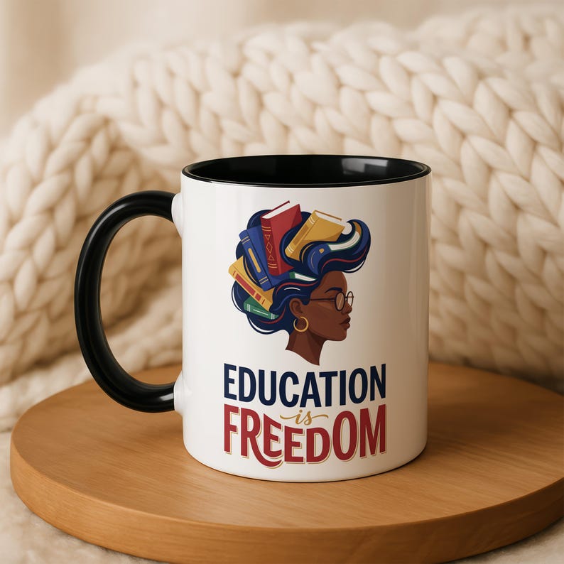White mug with black rim and handle, featuring graphic of woman with books in hair and text "Education is Freedom".