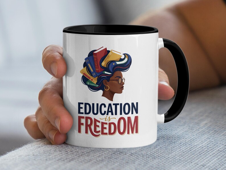 White mug with black rim features woman with books in hair and "EDUCATION IS FREEDOM" text.