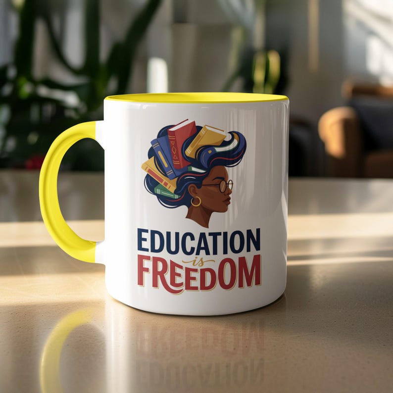 White mug with yellow handle, featuring a graphic of a woman with books for hair and "Education is Freedom" text.