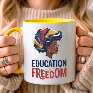 Yellow-rimmed mug with "Education is Freedom" text and colorful books.