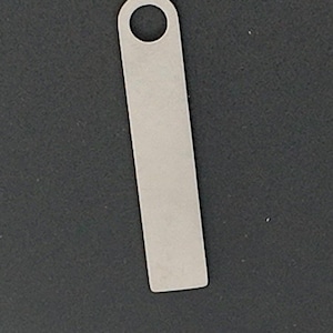 以下が含まれることがあります： 黒い持ち手が付いた白いセラミックマグカップで、黒い太字で「But First, Coffee」と書かれています。マグカップはぼやけた背景に置かれており、居心地の良い環境を示唆しています。