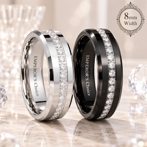 May include: Two 8mm width rings, one silver-toned and one black, each featuring a central channel set with a row of clear round stones. The interior of each band is engraved with the text EMPEROR'S CHOICE in a clean, sans-serif font style.