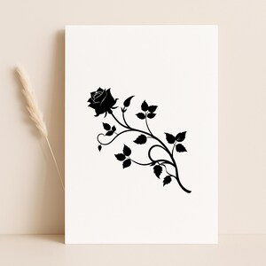 Pu&ograve; includere: Silhouette nera di una rosa con foglie e un gambo curvo su sfondo bianco. Il design floreale &egrave; un elemento decorativo, possibilmente per arte murale o un prodotto simile.