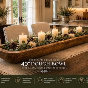 May include: A long, rectangular, hand-carved solid wood dough bowl measuring 40 inches in length. The bowl is filled with a decorative arrangement of six white pillar candles, green eucalyptus leaves, small white flowers, pinecones, and pumpkins.