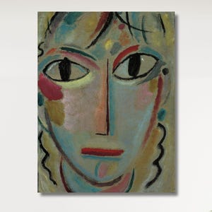 Puede incluir: Una gran pintura abstracta enmarcada de un rostro con grandes ojos negros, labios rojos y una nariz larga. La obra presenta una paleta de azules, rosas, amarillos y líneas negras. La pintura cuelga sobre una cama con ropa de cama blanca.