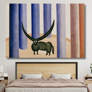 May include: A large canvas print of a whimsical painting. The artwork features a dark green creature with large, curved horns, set against a backdrop of vertical blue, brown, and beige columns. The painting is displayed above a bed.