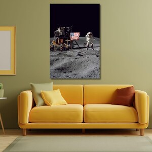 Peut inclure: Impression encadrée de l'image emblématique de la mission Apollo 11 sur la Lune. Un astronaute en combinaison spatiale se tient près du drapeau américain et du module lunaire. La surface lunaire est grise et cratérisée.