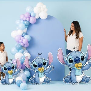 Puede incluir: Tres recortes del personaje Stitch azul en tama&ntilde;os variados de 76 cm, 91 cm y 114 cm. Cada recorte muestra al personaje con orejas grandes, una barriga azul claro y un chupete amarillo. Un arco de globos en blanco, azul y morado.