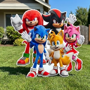 May include: A group of five colorful, cartoon character cutouts from the Sonic the Hedgehog franchise. The characters include Sonic, Tails, Knuckles, Shadow, and Amy Rose, all waving. The cutouts are standing on green grass.