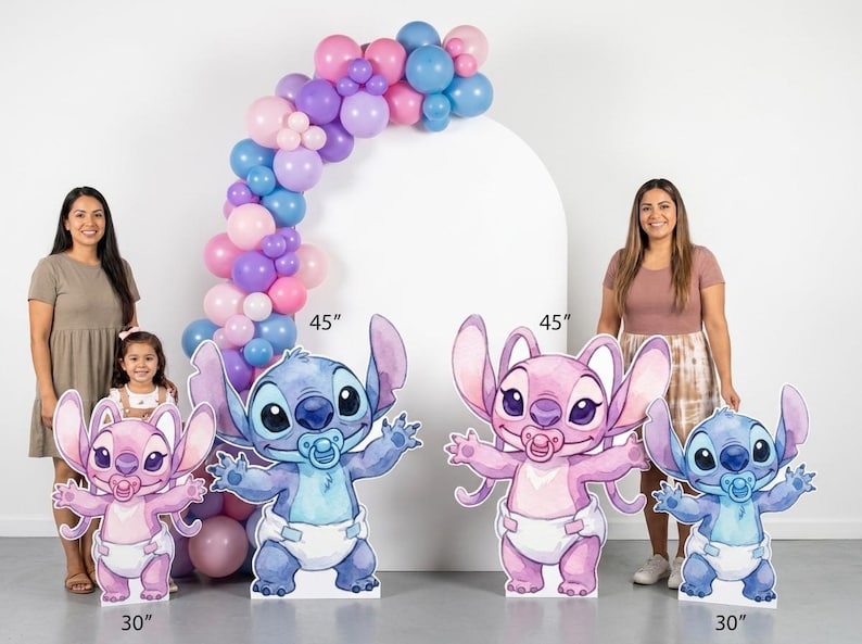 May include: Four character cutouts featuring blue and pink creatures with large ears, wearing diapers and pacifiers. Two cutouts are 45 inches tall and two are 30 inches tall. A balloon arch in shades of pink, purple, and blue is positioned behind them.