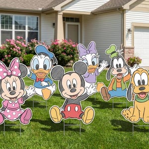 Puede incluir: Un conjunto de seis letreros de jard&iacute;n con personajes de dibujos animados: Mickey Mouse, Minnie Mouse, Donald Duck, Daisy Duck, Goofy y Pluto. Los personajes est&aacute;n en un jard&iacute;n con c&eacute;sped frente a una casa.