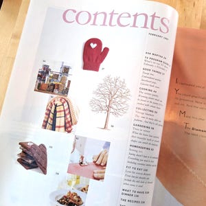 May include: Open magazine pages with the word "contents" at the top. The left page features images of a red mitten with a white heart, jars, a blanket, and a tree. The right page has text about a diamond necklace.