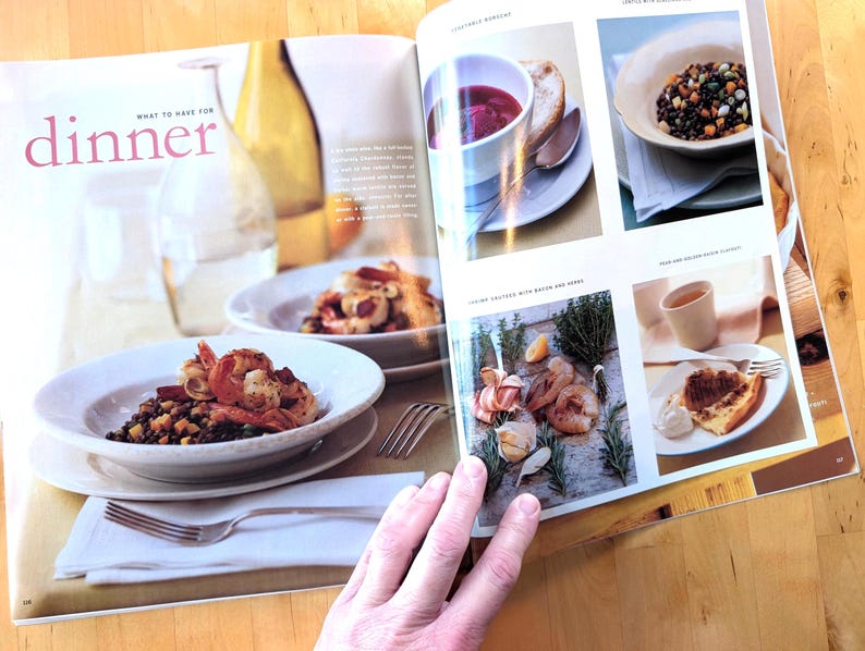 May include: A magazine spread featuring various dinner dishes. The page includes images of shrimp with a dark grain, a bowl of soup, and a slice of cake. The text "dinner" is visible in pink.