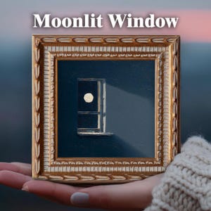 May include: A framed painting titled "Moonlit Window" depicts a window with a full moon and a beam of light against a dark blue background. The frame is ornate with gold and cream tones. The artwork is held in a hand.