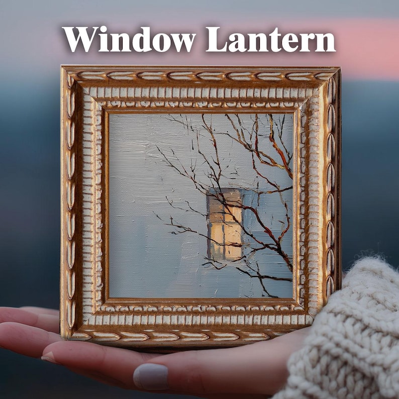 May include: A small framed painting with the text "Window Lantern". The artwork depicts a window with a warm glow, framed by bare tree branches against a pale blue background. The frame is ornate, with a gold and cream color.