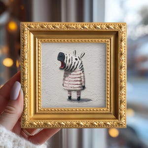 May include: A framed painting of a zebra character with a surprised expression. The zebra wears a pink and white striped outfit. The gold frame has an ornate, textured design.